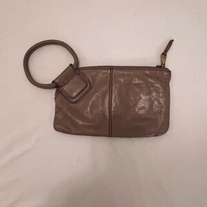 HOBO Sable leather wristlet clutch with a circular handle.